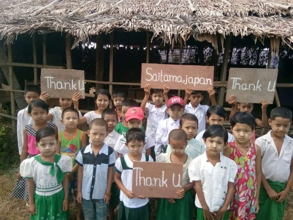 バゴー地方域の小学校(後景)支援に感謝する子どもたち(2020年)